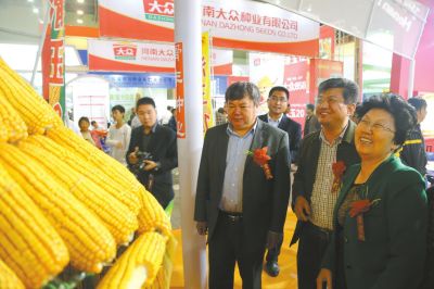 省种子协会会长马运粮（前排右三）向河南滑丰种业科技有限公司董事长赵秀珍（右一）了解该公司培育的玉米新品种。