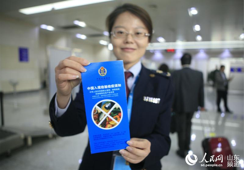 11日，济南检验检疫局工作人员向旅客介绍入境不能携带和邮寄1712号公告所规定的物品。（摄影：陈心同）